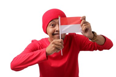 Endonezya bayrağı taşıyan, uzun kollu kırmızı tişörtlü heyecanlı Endonezyalı genç adam, 17 Ağustos 'ta Endonezya Bağımsızlık Günü' nü beyaz bir arka planda kutluyor.