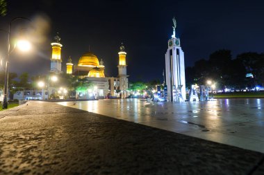 Sukabumi, Batı Java, Endonezya - 29 Nisan 2024: Sukabumi 'nin görkemli bir manzarası gece aydınlandı. Camide büyük altın bir kubbe ve yüksek minareler yer alıyor.