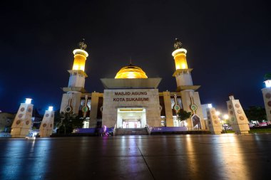 Sukabumi, Batı Java, Endonezya - 29 Nisan 2024: Sukabumi 'nin görkemli bir manzarası gece aydınlandı. Camide büyük altın bir kubbe ve yüksek minareler yer alıyor.