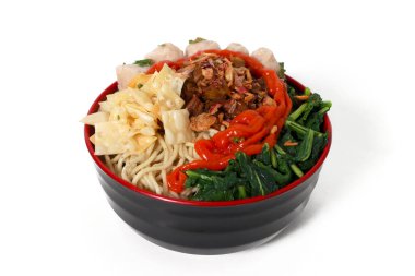 Bir kase Mie Ayam, tipik bir Endonezya yemeği, tavuklu erişte, doğranmış tavuk, köfte, köfte, yeşil sebze ve çeşitli malzemeler, beyaz bir arka planda izole edilmiş.