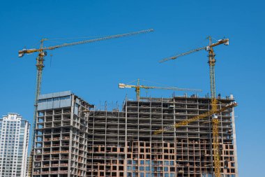 Yüksek katlı vinçleri olan bir inşaat alanı. Modern apartmanlar ve yeni bir konut kompleksi inşaatı. Yüksek kalite fotoğraf