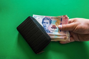 Yeşil arka planda cüzdanı olan bir paket Ukrayna 200 Hryvnia 'sı. Yüksek kalite fotoğraf