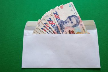 200 Ukrayna hrivniası yeşil arka planda beyaz bir zarfın içinde. Yüksek kalite fotoğraf