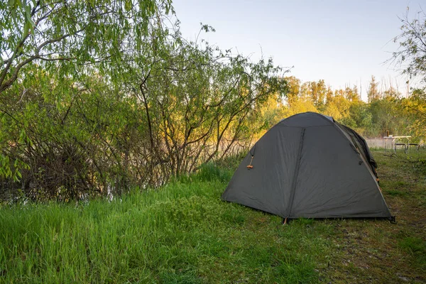 Yazın gün doğumunda nehrin kıyısında bir çadır kurun. Yüksek kalite fotoğraf