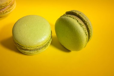 Sarı arka planda Fransız badem kurabiyeleri, üst manzara. Tatlı badem kurabiyeleri. Renkli Fransız kurabiyeleri. Yüksek kalite fotoğraf