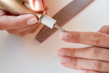 Verniği kaldırma süreci, evde elektrikli bir makineyle manikür. İşlem sırasında iş yüzeyini soyun. Yüksek kalite fotoğraf