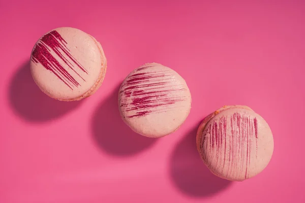 Renkli Fransız kurabiyeleri. Pembe arka planda Fransız kurabiyeleri, üst manzara. Tatlı badem kurabiyeleri. Yüksek kalite fotoğraf