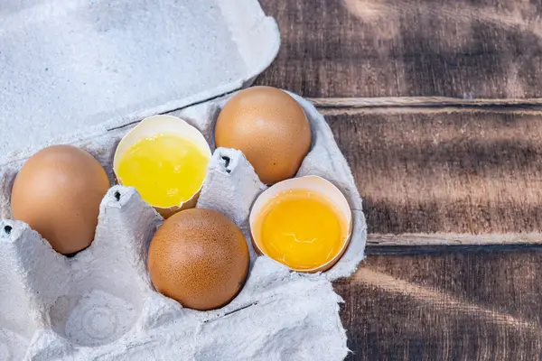 Homemade chicken eggs. Broken eggs. Egg yolk, white. Eggs in a paper tray. High quality photo