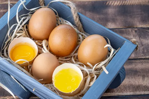 Homemade chicken eggs. Broken eggs. Egg yolk, white. Eggs in a wooden stand. High quality photo