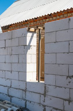 Beyaz havalandırmalı beton bloktan penceresi olan inşa edilmiş bir duvar, tuğla. Havalandırmalı beton bloklar yerleştirmek. Havalandırmalı beton bloklar, tuğlalar. Yüksek kalite fotoğraf