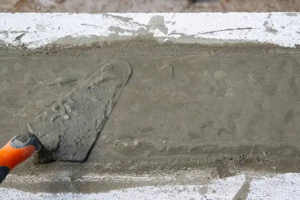 Somut çözelti dökülüyor. Spatula çözeltiyi yumuşatmak için. Kendi ellerinle bir ev inşa etmek. Yüksek kalite fotoğraf