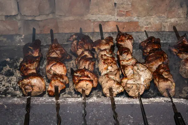 Izgarada bir sürü kebap şişi, dumanın içinde yakın plan kömürlerin üzerinde. Yüksek kalite fotoğraf