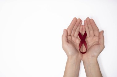 Dünya Kanser Günü 'nün sembolü olarak kırmızı kurdele tutan kadın beyaz arka planda, göğüs kanseri farkındalığı işareti. Yüksek kalite fotoğraf