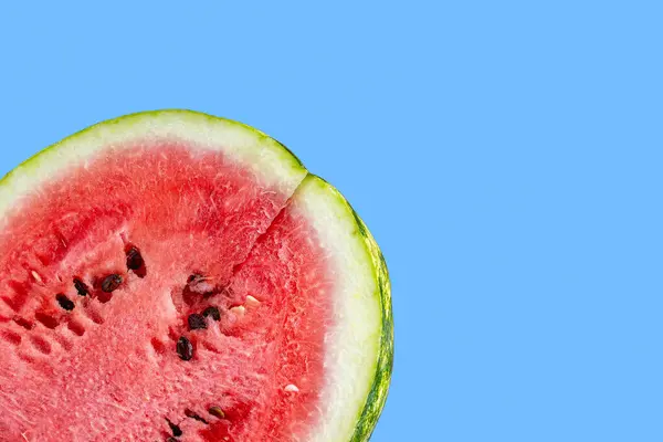 Mavi arka planda sulu bir karpuz parçası. Mavi arka planda izole edilmiş karpuz dilimi. Olgun, sulu, vitamin dolu karpuz. Yüksek kalite fotoğraf