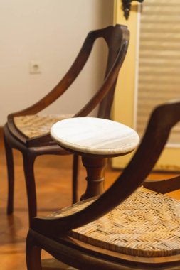 Odadaki bir masanın üzerindeki tahta sandalye.