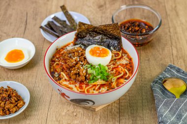 Ahşap masada domuz etli Japon eriştesi ve yumurta.