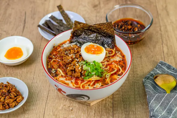 Ahşap masada domuz etli Japon eriştesi ve yumurta.