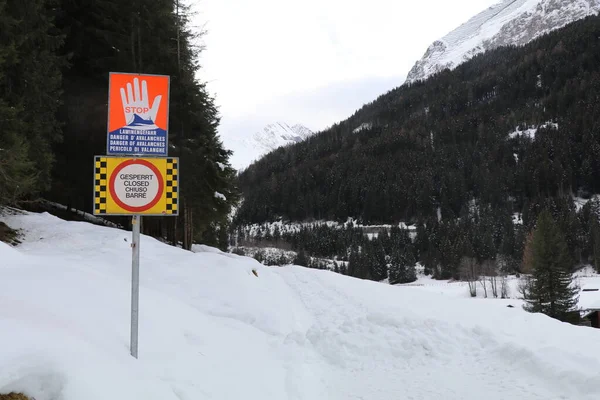 multi language signs indicating road closure due risk of avalanches