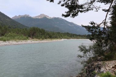 Büyük bir nehir olan Lech vadide dağlar ve bulutlu bir gökyüzü, kasvetli bir atmosfere neden olur.