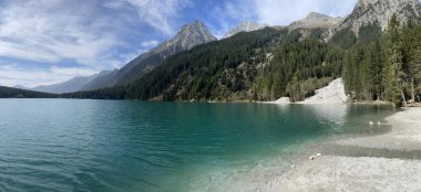 panoramic view of Lake Antholz with a pebble beach and the surrounding mountains clipart