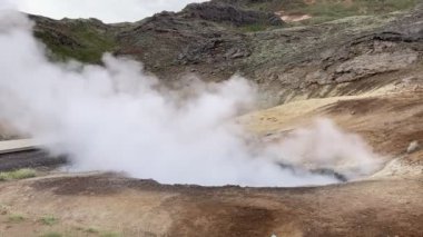 İzlanda 'da duman rüzgarda esiyor ve kara çamur duman bulutunda zıplıyor.