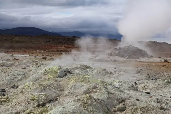 İzlanda 'nın Namaskjard jeotermal bölgesinde buhar bulutları ve renkli kayalar