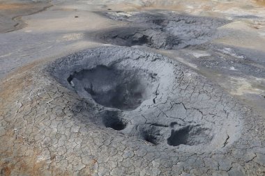 Koyu gri çamur İzlanda 'nın Namaskard jeotermal bölgesinde jeotermal bir çömlekte kaynayıp köpürüyor.