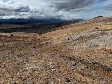 Myvatn Gölü 'nün yanındaki namaskard' ın jeotermal bölgesinde bitkisiz renkli dağların olduğu kurak bir arazinin manzarası.