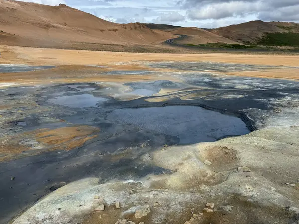 Toprağın turuncu, sarı, mavi, gri, beyaz renklerinde olduğu çorak bir jeotermal alan. 