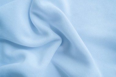 Açık mavi kıvrımlı kumaş arka plan. Dalgalı kumaş
