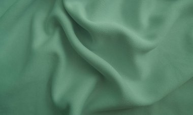 Kırışık kumaş dokusu. Yeşil dalgalı kumaş arkaplanı