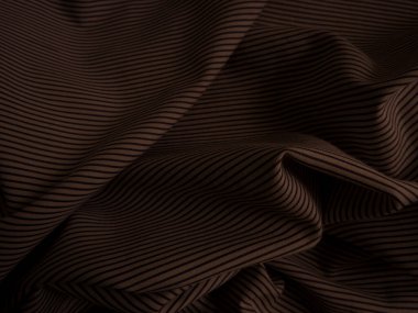 Koyu kahverengi buruşuk kumaş arkaplan. Dalgalı soyulmuş kumaş.