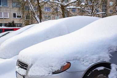 Otoparktaki arabalar tamamen karla kaplı.