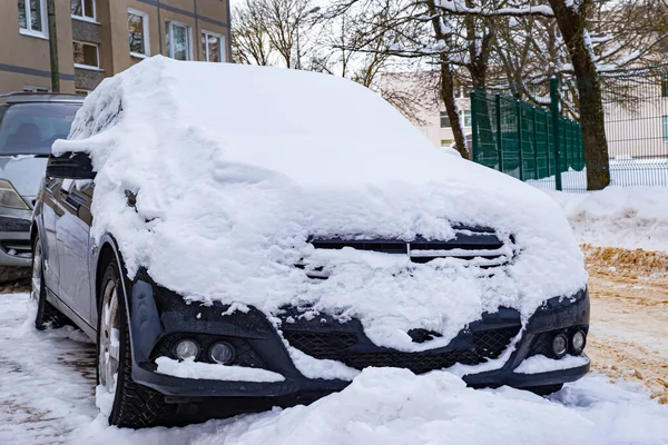 stock image black car standing near the house covered with snow