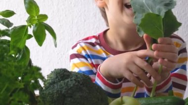 Çocuk yeşil sebzelere bakıyor. Yakın plan. Yüksek kaliteli FullHD görüntüler