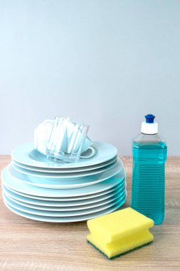 Plastic mockup with dishwashing gel and yellow sponges and clean dishes. Purity concept