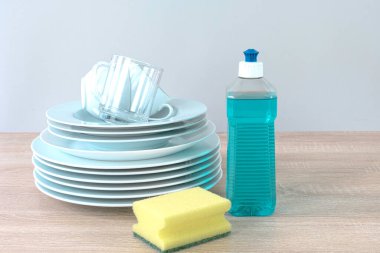 Plastic mockup with dishwashing gel and yellow sponges and clean dishes. Purity concept