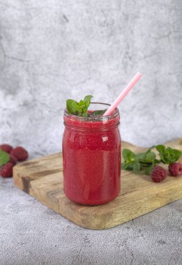 Gri beton arka planda bir kavanozda ahududu smoothie. Yüksek kalite fotoğraf