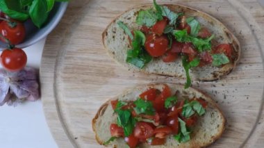 Lezzetli bir bruschetta mayalı tostu kiraz domatesli ve taze fesleğenli, geleneksel İtalyan yüksek kalite FullHD görüntülü.