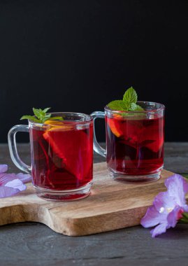 Tahta bir masada cam bardakta Red Hot Hibiscus çayı. dikey fotoğraf Yüksek kalite fotoğraf