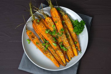 Kahverengi arka planda bir tabakta pişmiş havuç. Yüksek kalite fotoğraf