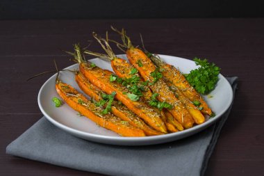 Kahverengi arka planda bir tabakta pişmiş havuç. Yüksek kalite fotoğraf