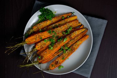 Kahverengi arka planda bir tabakta pişmiş havuç. Yüksek kalite fotoğraf