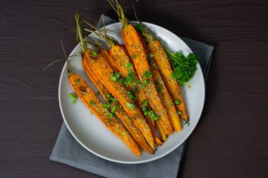 Kahverengi arka planda bir tabakta pişmiş havuç. Yüksek kalite fotoğraf