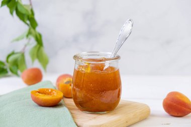 Cam kavanozda ev yapımı organik reçel ve ahşap kırsal masada olgun kayısılar. Yüksek kalite fotoğraf