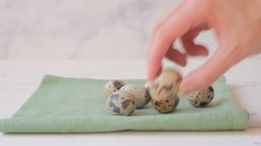 Bir kadın masanın üzerindeki peçeteye bıldırcın yumurtası bırakıyor. Organik ürünler. Yüksek kaliteli FullHD görüntüler