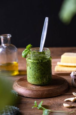 Köy masasında bir kavanozda fesleğen pesto. Dikey fotoğraf. Yüksek kalite fotoğraf