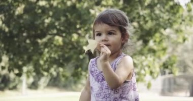 Yaz sonlarında parkta gezen tatlı bir kız. 4K RAW 'da bir sinema kamerasında çekildi..