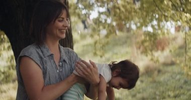 Anne üzgün, kıvranan küçük kızı teselli ediyor. 4K RAW 'da bir sinema kamerasında çekildi. Anamorfik bokeh.