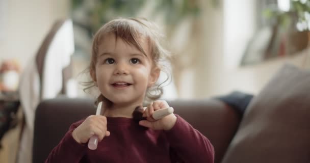 お母さんのメイクブラシで遊んでかわいい赤ちゃんの女の子 シネマカメラで4K Rawで撮影 — ストック動画